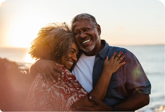 Couple embracing outdoors in warm evening light.